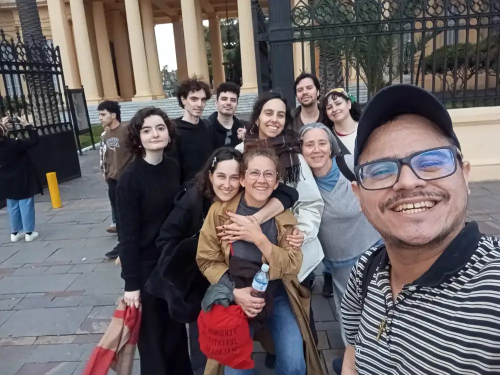 Sebastián taking a selfie with a group of guests at the entrance of Chacarita cemetery