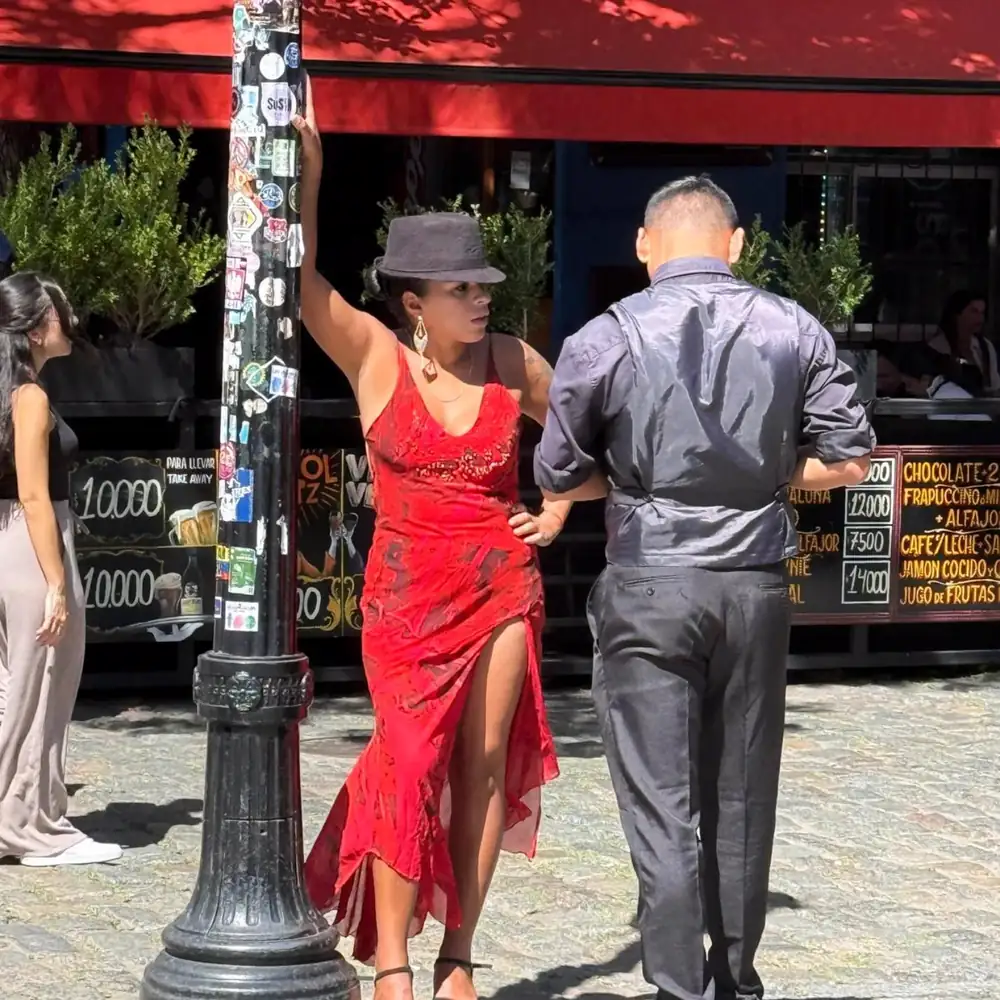 A tango couple posing on a street corner in Caminito