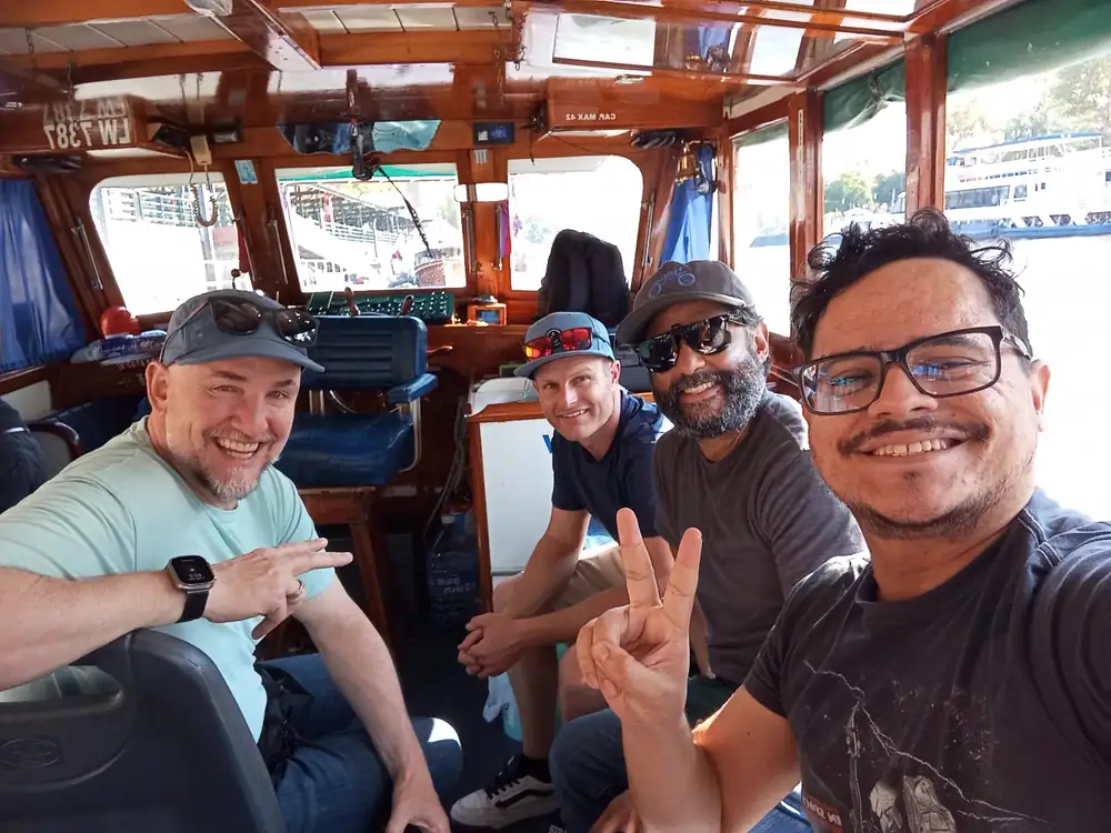 Sebastián and guests smiling inside a wooden boat in Tigre